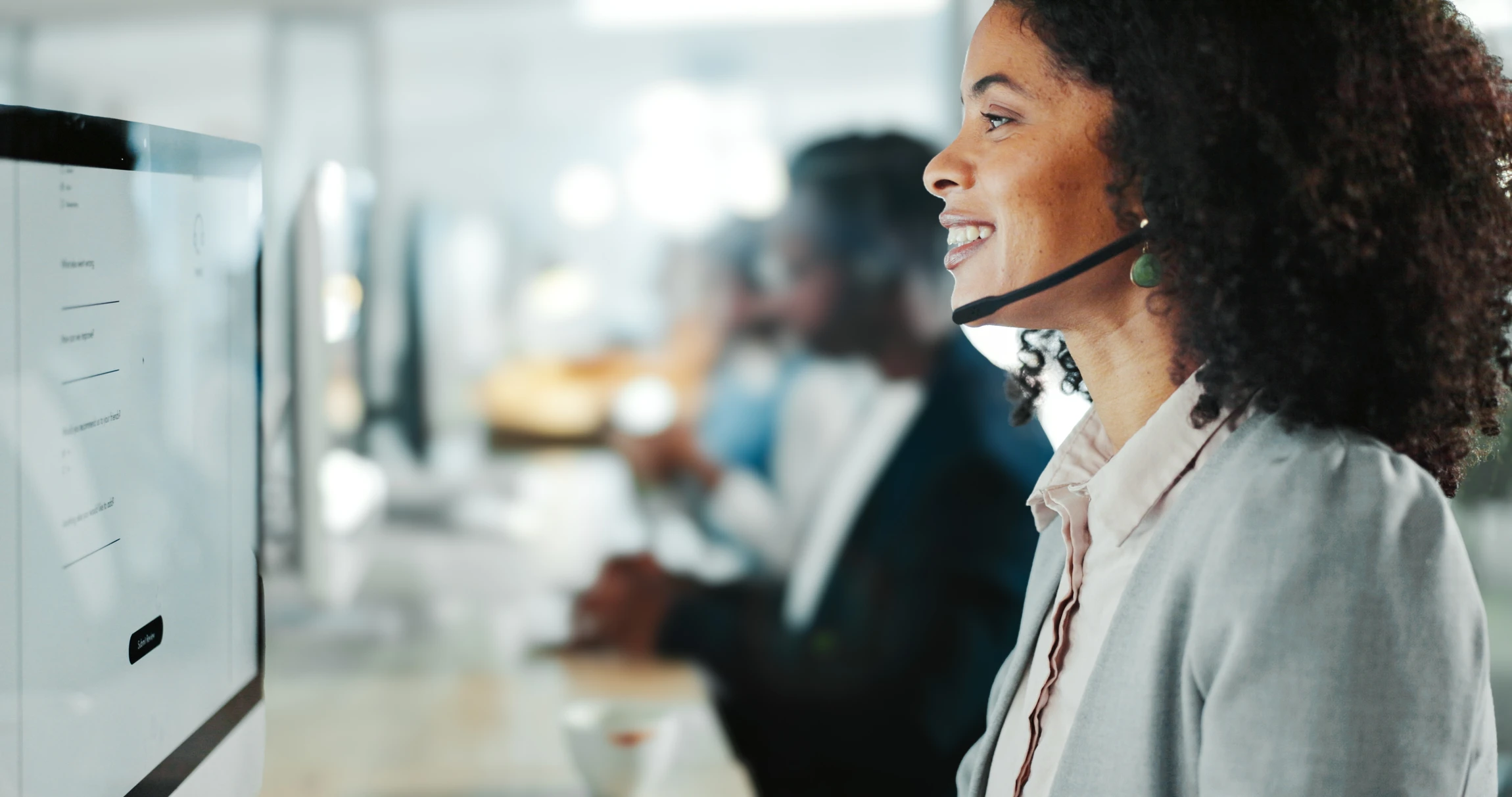 Technicien de sécurité en centre de télémaintenance pilotant depuis un poste informatisé une installation de vidéosurveillance : écran d'ordinateur affichant des flux vidéo de caméras de surveillance, un deuxième écran avec un système d'alarme connecté, l'opérateur concentré, en train de monitorer les installations clients en direct. Environnement professionnel moderne, bien éclairé, montrant clairement le pilotage à distance de systèmes de sécurité via des interfaces numériques.